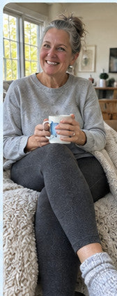 Illustrativ hemmabild av en silverhårig kvinna i mörkgrå leggings